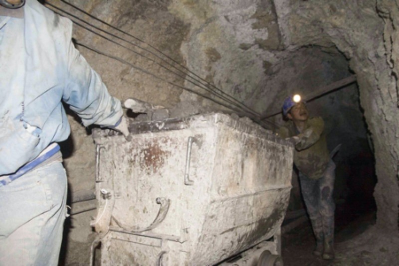 Photo d'ouvriers dans une mine transportant des graviers
